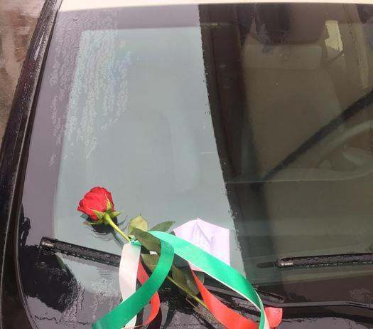 Un rosa ed un messaggio di incoraggiamento lasciati su auto carabinieri