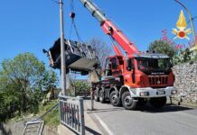 Probabile guasto al freno – Compattatore dei rifiuti in sosta travolge auto e finisce in un cortile privato